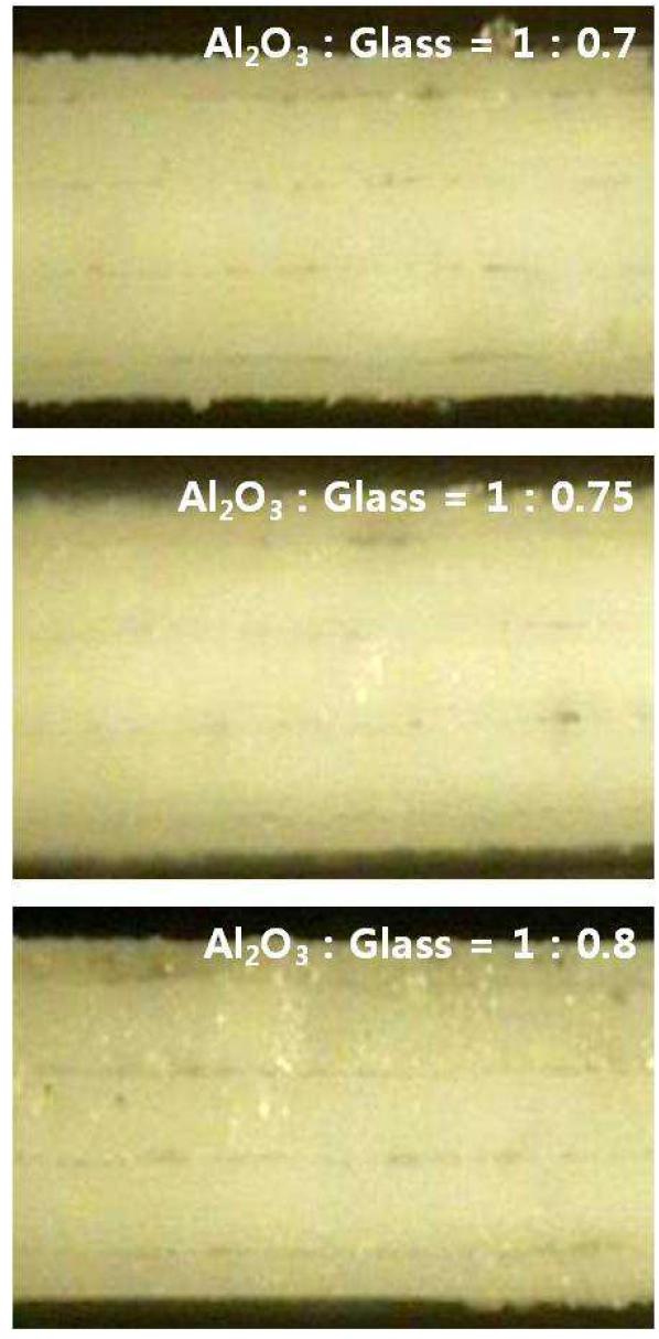 알루미나 테이프와 유리 프리트 테이프의 적층비에 따르는 자기구속 소결체의 단면 사진.