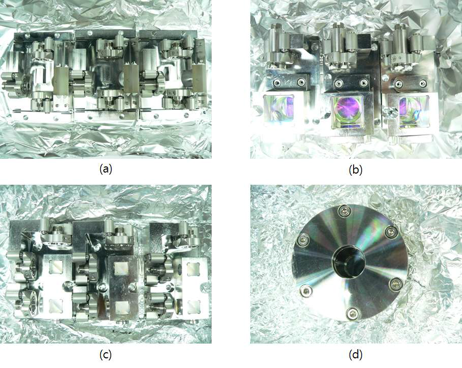 Photography of the optical measurement system; (a) Straightness measurement sensor; (b) Laser interferometer (source part); (c) Laser interferometer (detecting part); (d) Silicone oil mirror for vacuum environment