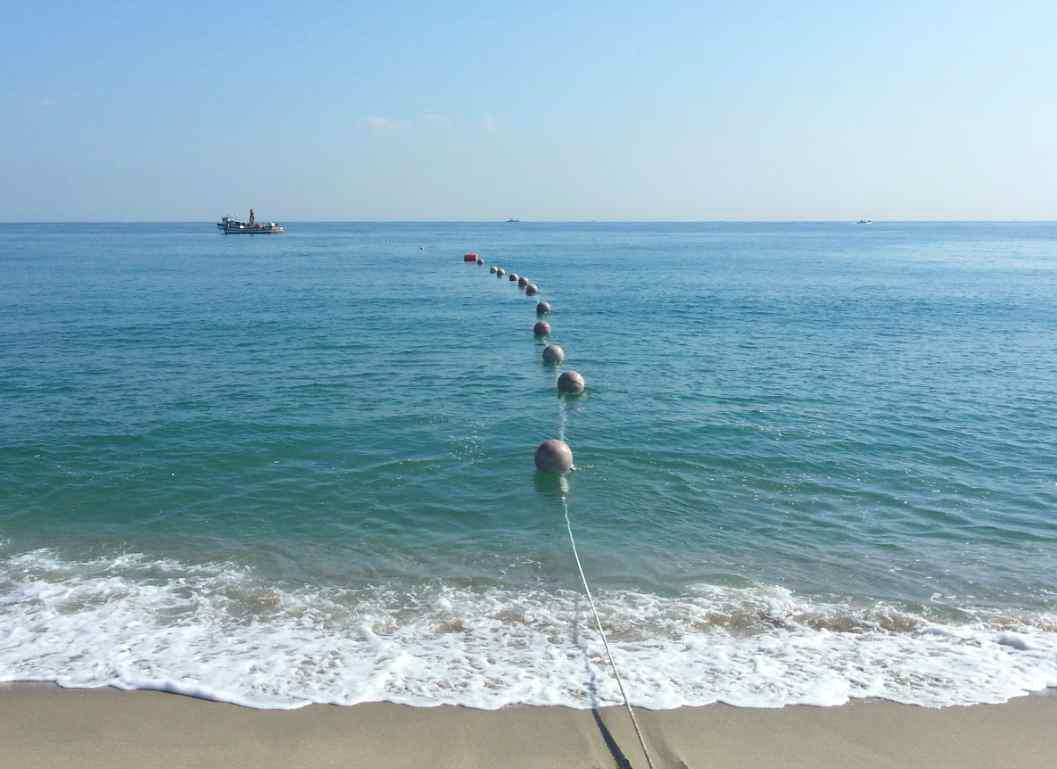 Bottom mount acoustic cable moving off the beach using the ship