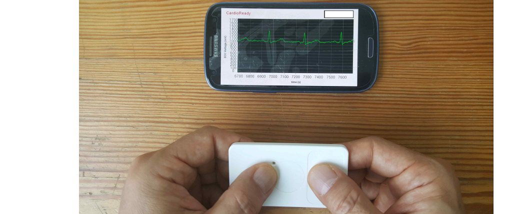 개발된 손가락 접촉 심전도 동글을 사용하여 심전도를 측정하는 사진