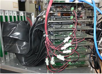 금속 망사형 접지로 둘러싼 64 pin flat cable을 각각의 검출기와 signal process electronics에 연결한 모습을 접사한 사진.