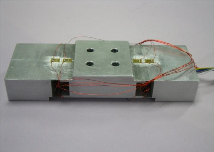 Manufactured two-axis force sensor with two step plate beams.