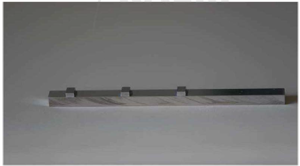 Badziak 박사팀이 사용한 타겟의 사진; 알루미늄 막대 위에 3개 의 타젯이 올려져 있으며 각 타겟은 를라스틱 (C1 불순불이 들어있는 CH) 이 코팅되어 있는 알루미늄(A1)이나 구리 (Cu) 블록임.